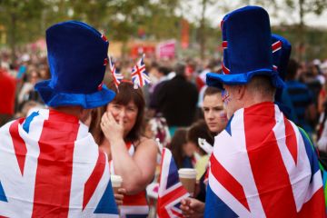Unknown fans dressed in Union Jack flags and hats in the Olympic Park in Stratford, East London Unknown fans dressed in Union Jack flags and hats in the Olympic Park in Stratford, East London