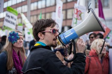 A demonstrator uses a megaphone to call for an end to the use of fossil fuels