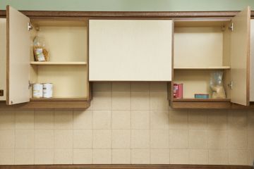 Open kitchen cupboards with very little food inside
