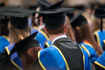  Students sit in a row at their university graduation ceremony.
