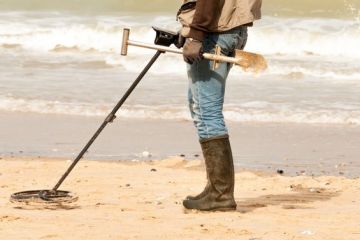 Person on beach using metal detector