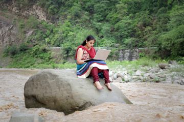 Indian woman in river with laptop
