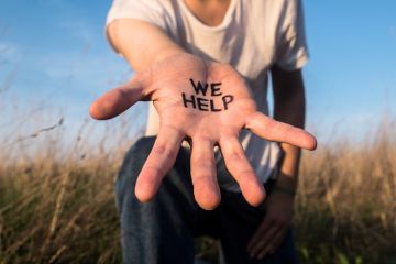 Extended hand with “We help” on the palm, illustrating assistance to international students
