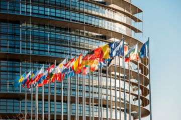 The European Parliament building in Strasbourg, France with flags waving on a spring evening