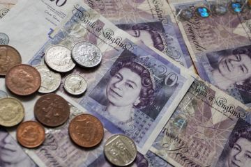 Twenty Pound Notes and coins of pounds sterling the currency of the UK. Twenty Pound Notes and coins of pounds sterling the currency of the UK.