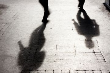 Shadow of two people on pattered sidewalk in black and white Shadow of two people on pattered sidewalk in black and white