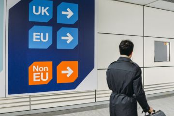 Passenger walks past sign prior to immigration control pass a sign pointing towards queues for UK, EU and Non-EU passport holders. Passenger walks past sign prior to immigration control pass a sign pointing towards queues for UK, EU and Non-EU passport holders.