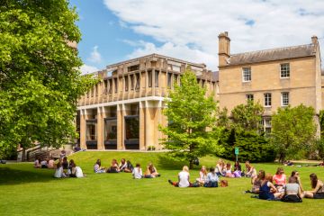 Students relaxing on the grass outside Balliol College of Oxford University Students relaxing on the grass outside Balliol College of Oxford University