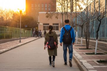 Two Chinese students Walking Side by Side on University Campus in Xi'an, China March 2018