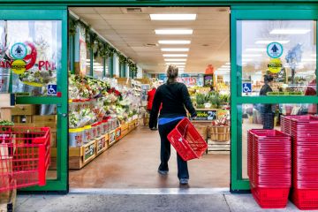 Trader Joe's customer with shopping basket by store entrance Trader Joe's customer with shopping basket by store entrance