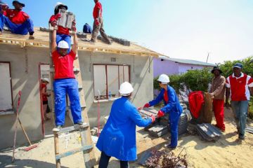 Community members building a low cost house as a team in Soweto. Community members building a low cost house as a team in Soweto.