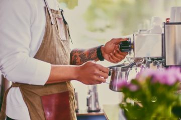 Close up image of a man preparing late in a coffee machine. Close up image of a man preparing late in a coffee machine.