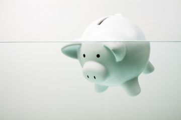 Piggy bank drowning in debt