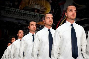 Identical men with bar codes on a production line