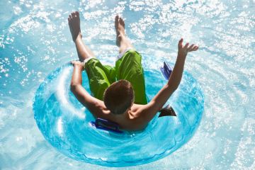 Student or teenager enjoying lazy river in rubber ring