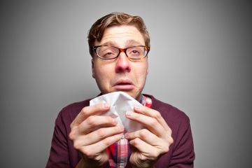 Man with the flu sneezes
