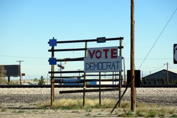 Sign supporting the Democratic Party on a shabby rack beside the road