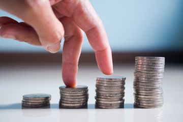 Fingers walk up columns of coins, symbolising levelling up