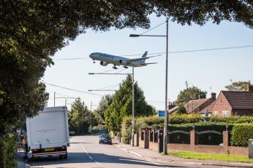 London, Heathrow, United Kingdom - October 3, 2016 American Airlines plane approaching to London Heathrow airport, low above housing estate.