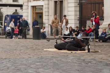London, uk - september 01, 2009 A street artist in covent garden entertains the audience with the game of limbo