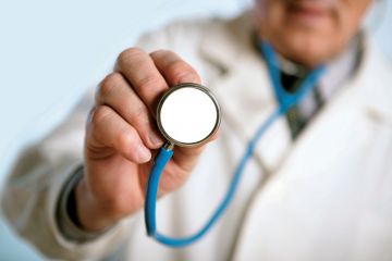Male doctor holding stethoscope Male doctor holding stethoscope