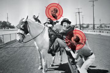 Man being helped to mount a white horse