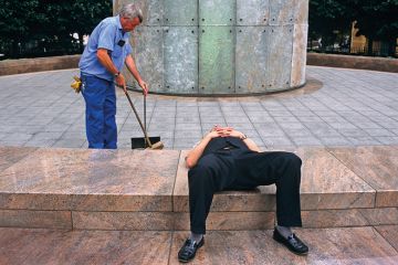 Man lays down while another works behind Man lays down while another works behind