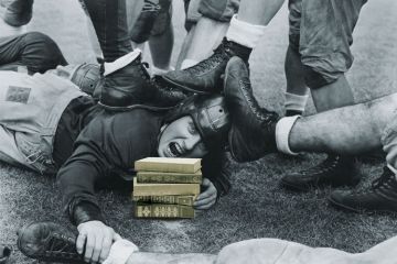 Man lying beneath rugby pile-up