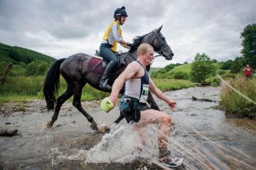 Man racing horse across shallow river Man racing horse across shallow river