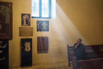 Man sitting in sunlight lit church Man sitting in sunlight lit church