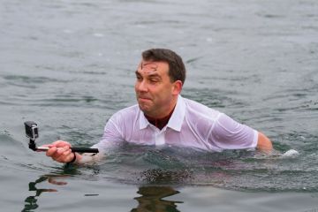 Man standing in water taking selfie photograph Man standing in water taking selfie photograph