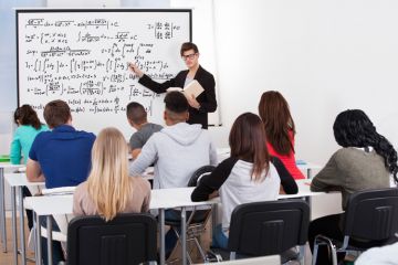 Man teaching mathematics to class of students Man teaching mathematics to class of students
