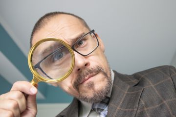 Man looking through a magnifying glass
