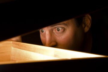 Man looking under box lid