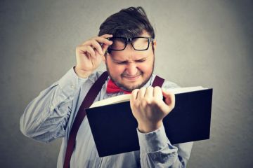 Man struggling to read book