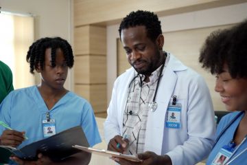 A Black doctor teaches two Black students A Black doctor teaches two Black students
