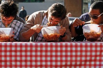 Men eating pasta in speed eating competition Men eating pasta in speed eating competition