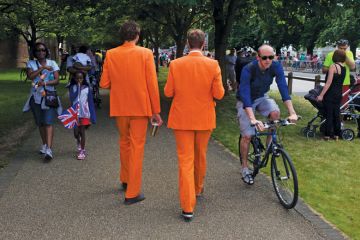 Men walk along wearing matching orange suits