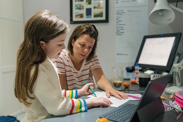 A mother helps child with homework
