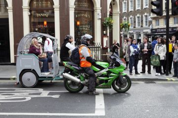 Motorbike and rickshaw at traffic lights