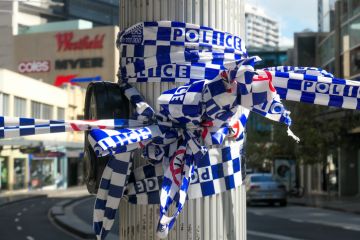 NSW Police cordon tape wrapped around a light pole. This image was taken at the corner of Oxford Street and Hollywood Avenue, Bondi Junction