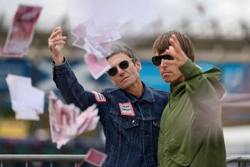 Oasis lookalikes of Liam and Noel Gallagher throwing fake money pose for photographs. To illustrate universities using ‘dynamic pricing’ with overseas students offered thousands off fees.