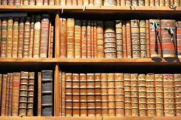 Old books arranged on library bookshelves Old books arranged on library bookshelves
