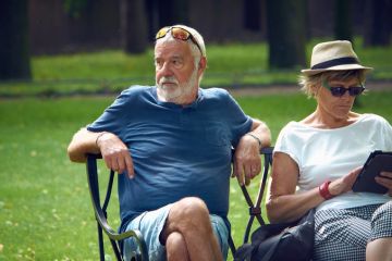 Older couple rest on a park bench