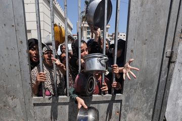 Displaced Palestinians including women and children wait to receive food distributed by aid organisations in Gaza City, Gaza on 29 May 2025. The situation highlights the growing desperation and urgent need for humanitarian assistance. Displaced Palestinians including women and children wait to receive food distributed by aid organisations in Gaza City, Gaza on 29 May 2025. The situation highlights the growing desperation and urgent need for humanitarian assistance.