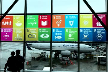 Panama CityPanama, October 18, 2018 The Global Goals displayed in Spanish on the windows at Panama City Tocumen International Airport. Mother and child looking out to see the planes.