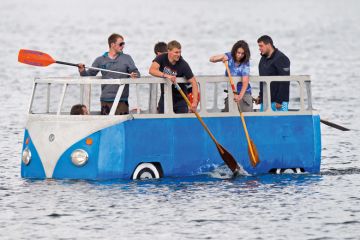 People paddling in floating Volkswagen camper van People paddling in floating Volkswagen camper van
