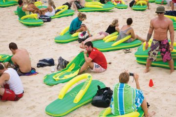 People sitting on the beach on giant lilos