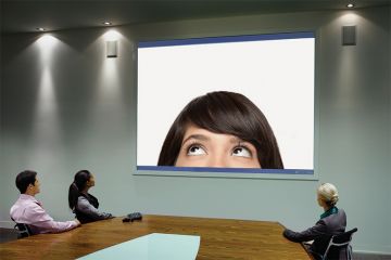 People taking part in Skype call in conference room