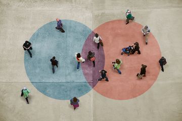 Pedestrians on a concrete floor with a blue and red Venn diagram, shot from above. To illustrate mission groups of universities.